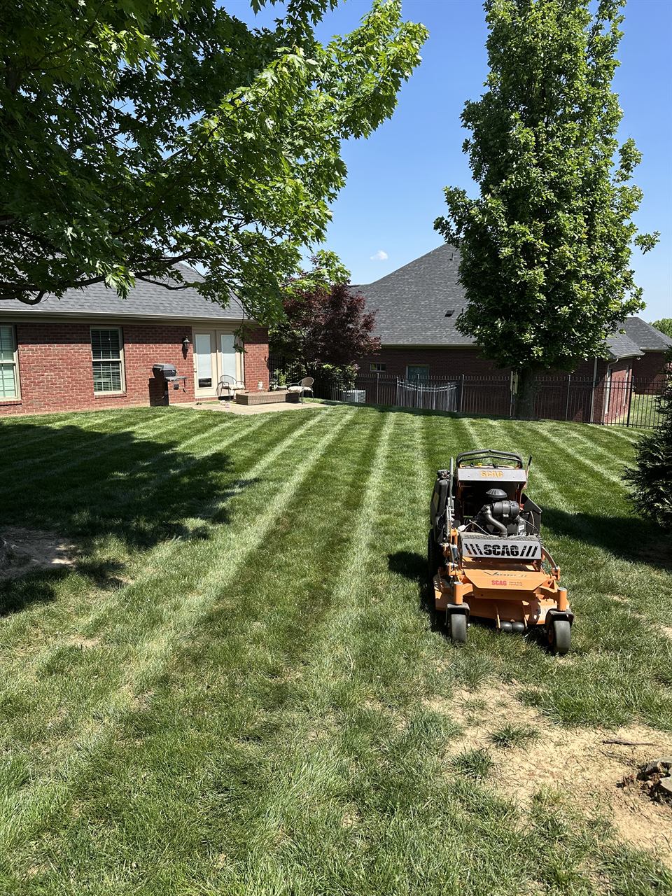 A Horizon Outdoor Solutions commercial mower cutting crisp stripes into a healthy green lawn at an Owensboro, KY home